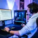 a man wearing a headset sitting at a computer desk