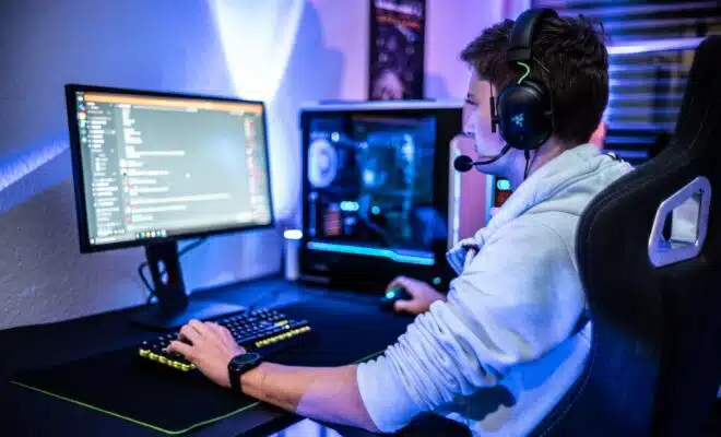 a man wearing a headset sitting at a computer desk