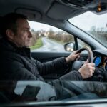 Conducteur de nuit en Anjou regardant une route mouillée depuis son habitacle en heure d'hiver