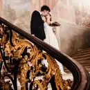 man and woman kissing while standing on stairs