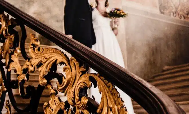 man and woman kissing while standing on stairs