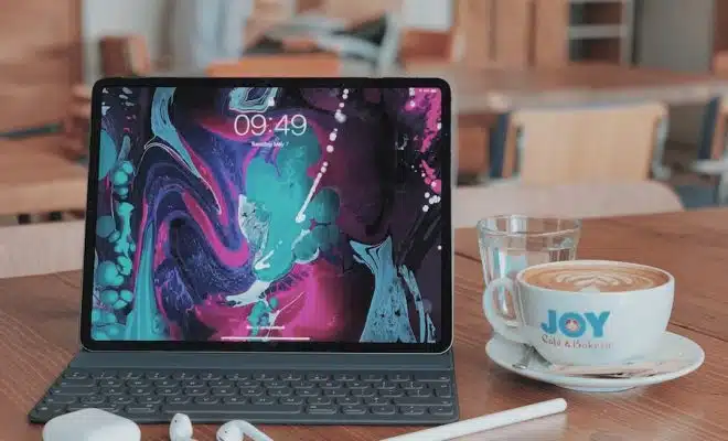 black iPad beside cup of coffee on table