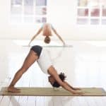 Femme en posture de yoga sur son tapis de yoga antidérapant et bio