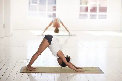 Femme en posture de yoga sur son tapis de yoga antidérapant et bio