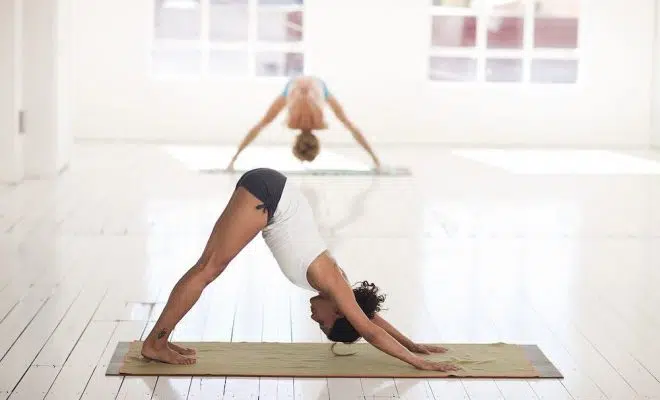 Femme en posture de yoga sur son tapis de yoga antidérapant et bio