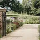 brown wooden gate near green grass and trees during daytime