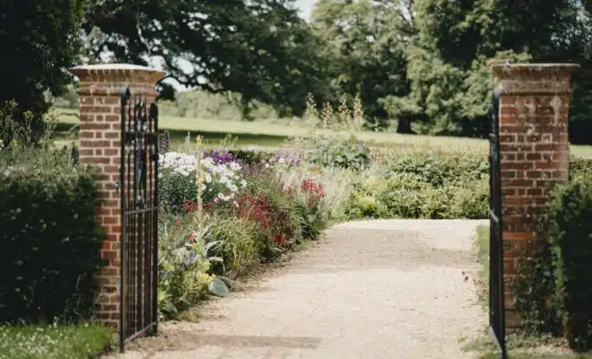 brown wooden gate near green grass and trees during daytime